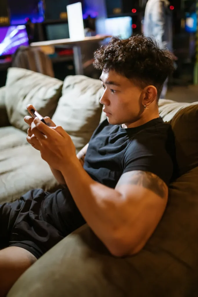 Home 2 Joven en el sofá consultando una app de apuestas deportivas en el móvil