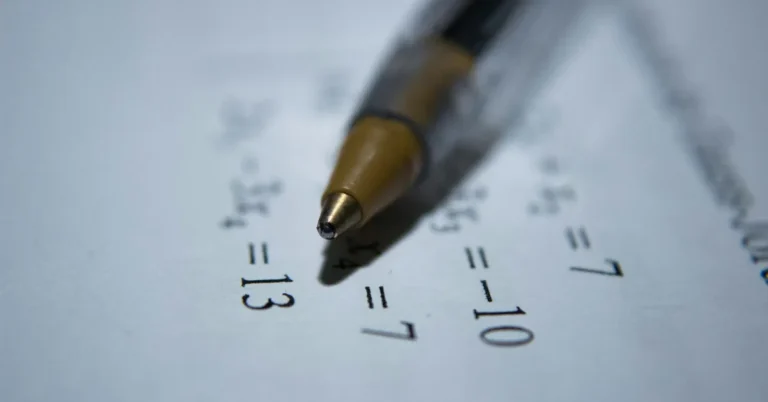 Bolígrafo apoyado sobre una hoja con operaciones matemáticas