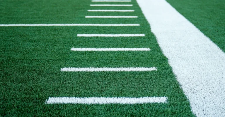 Marcas blancas de las yardas junto a la banda de un campo de fútbol americano